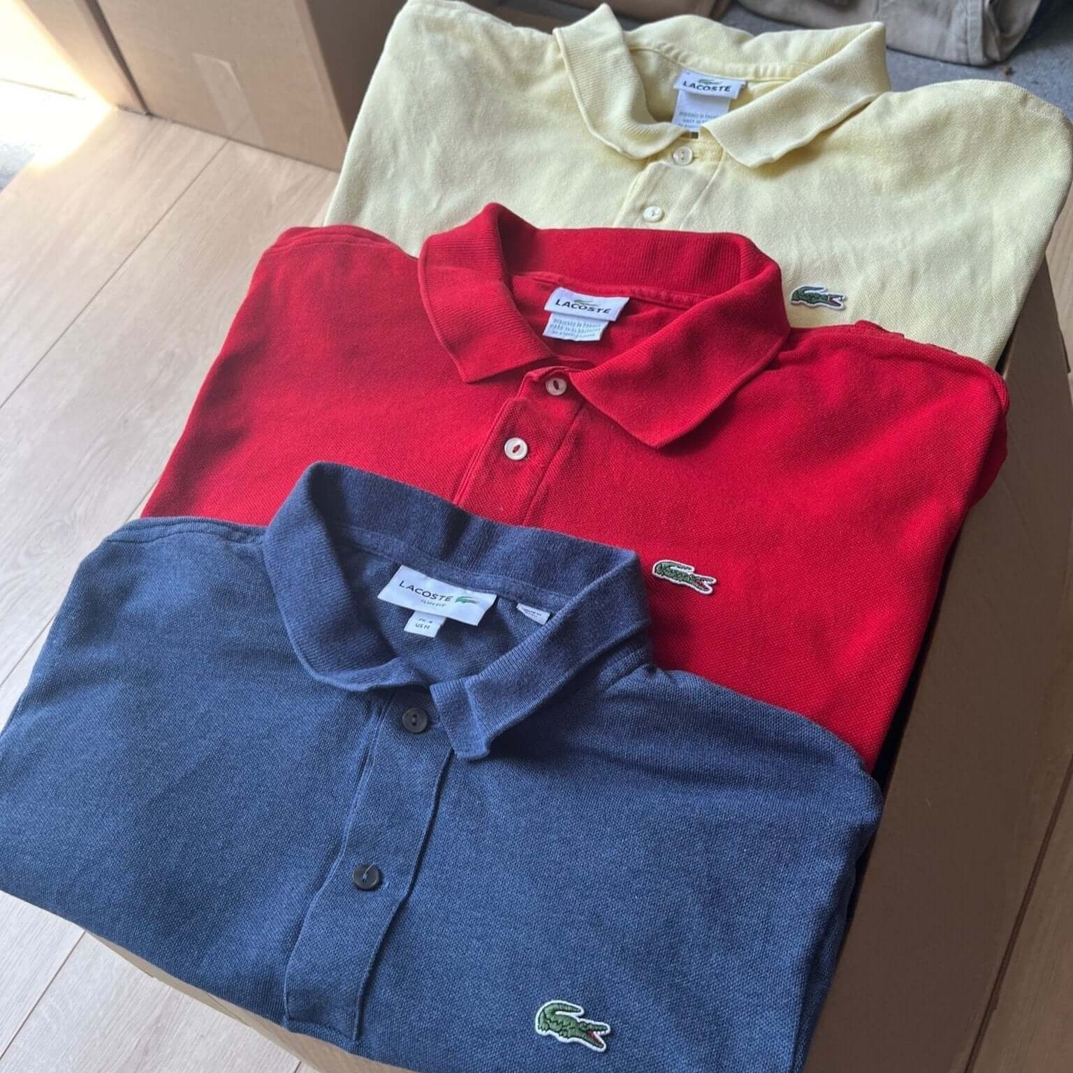 Box de polos Lacoste vintage pliés – coloris bleu et rouge – vente en gros vêtements seconde main – Place Wholesale